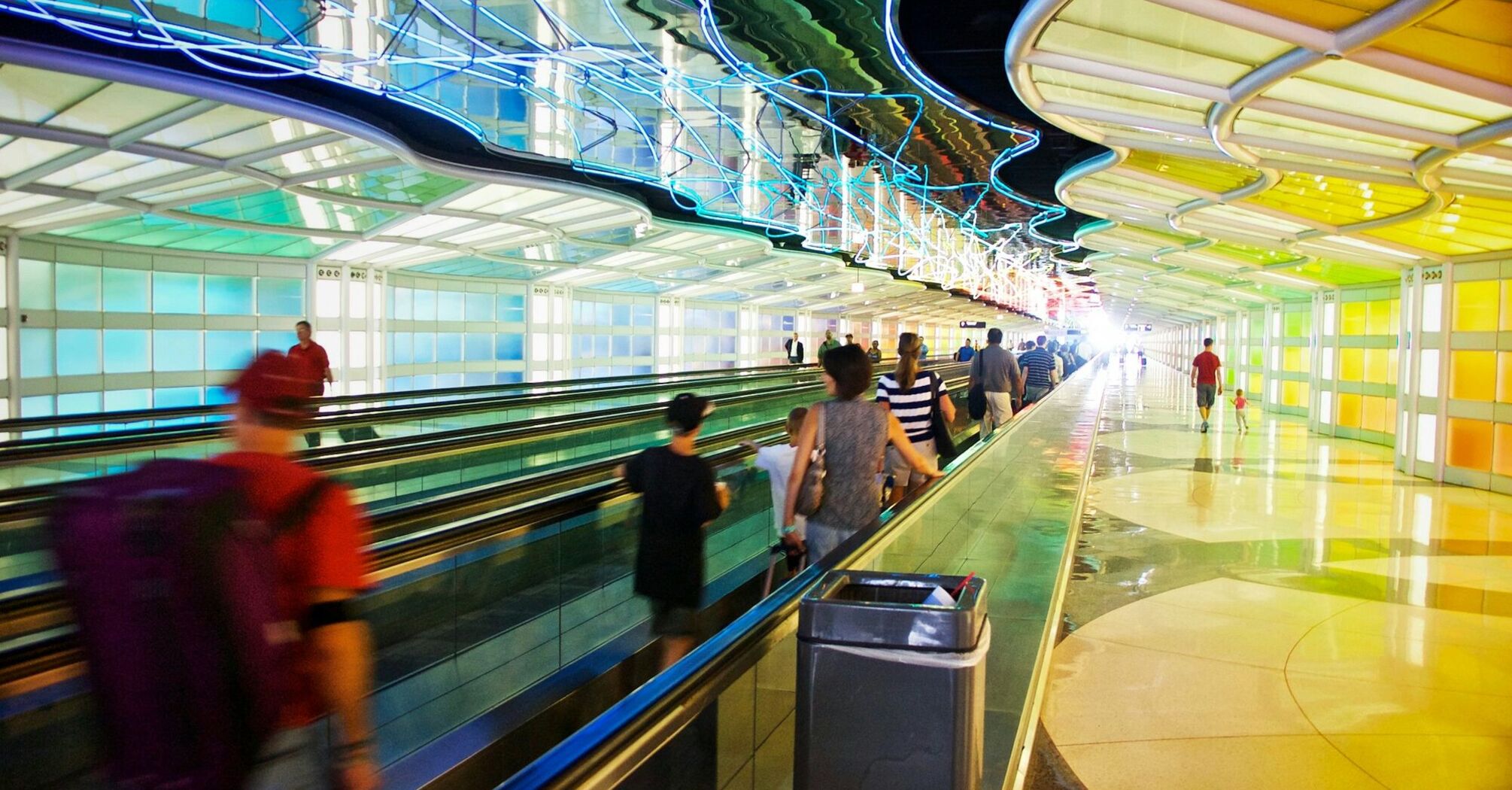 Passengers walking through a colorful tunnel at O'Hare International Airport