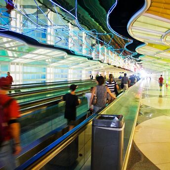Passengers walking through a colorful tunnel at O'Hare International Airport