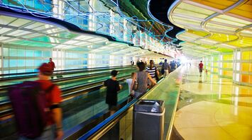 Passengers walking through a colorful tunnel at O'Hare International Airport