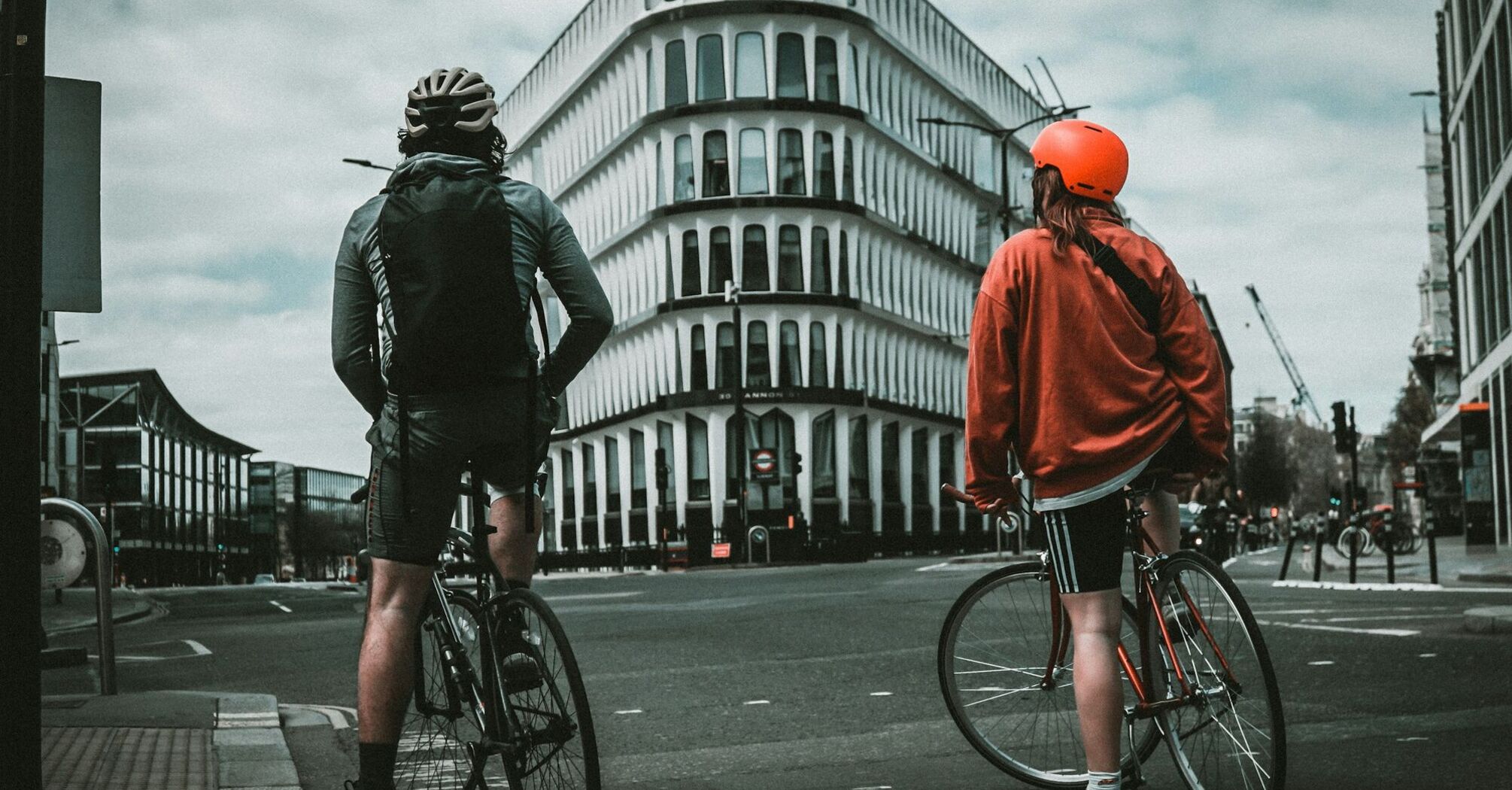 Two cyclists waiting at a London intersection