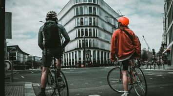 Two cyclists waiting at a London intersection