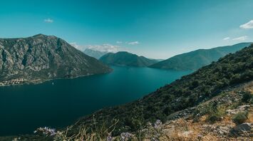 green mountains beside blue sea under blue sky during daytime