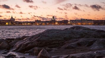 Rocky shoreline with the Helsinki skyline at sunset