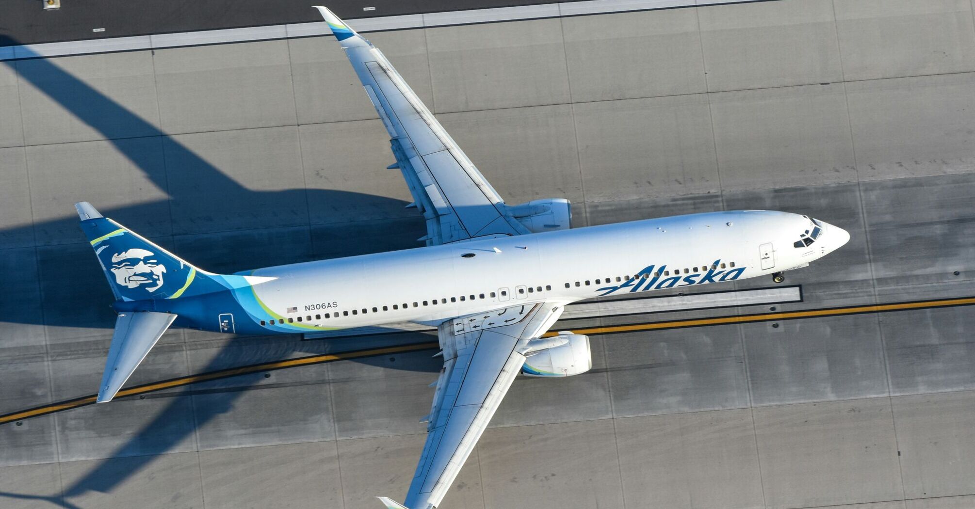 a white and blue airplane flying over a runway