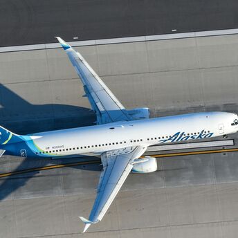 a white and blue airplane flying over a runway