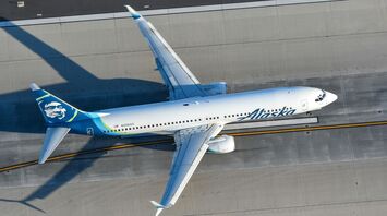 a white and blue airplane flying over a runway