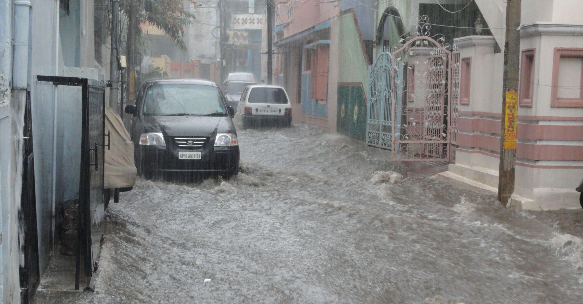 Flooded street with cars partially submerged in water