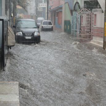 Flooded street with cars partially submerged in water
