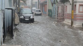 Flooded street with cars partially submerged in water