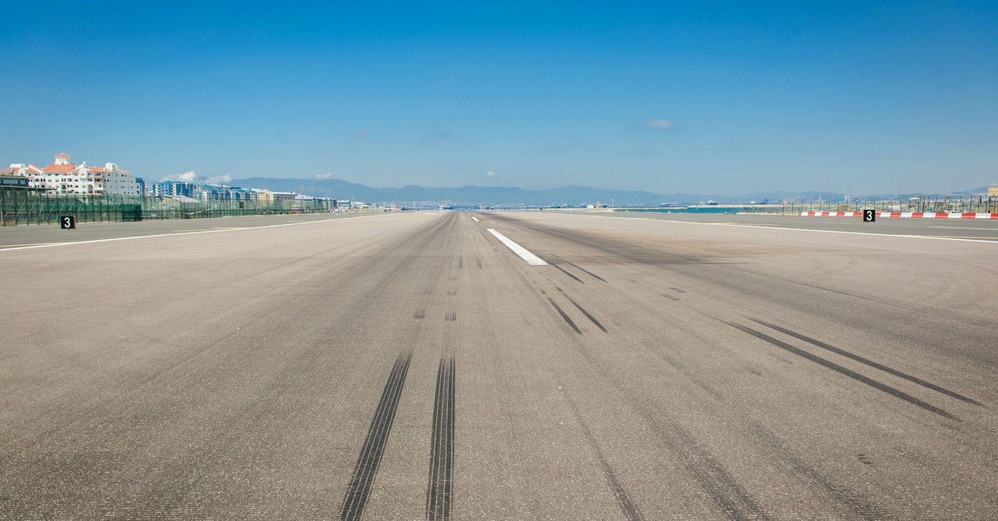 wheel marks on gray concrete pavement during daytime