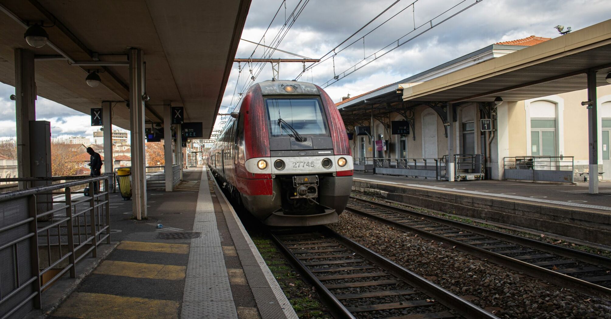 a red and white train pulling into a train station