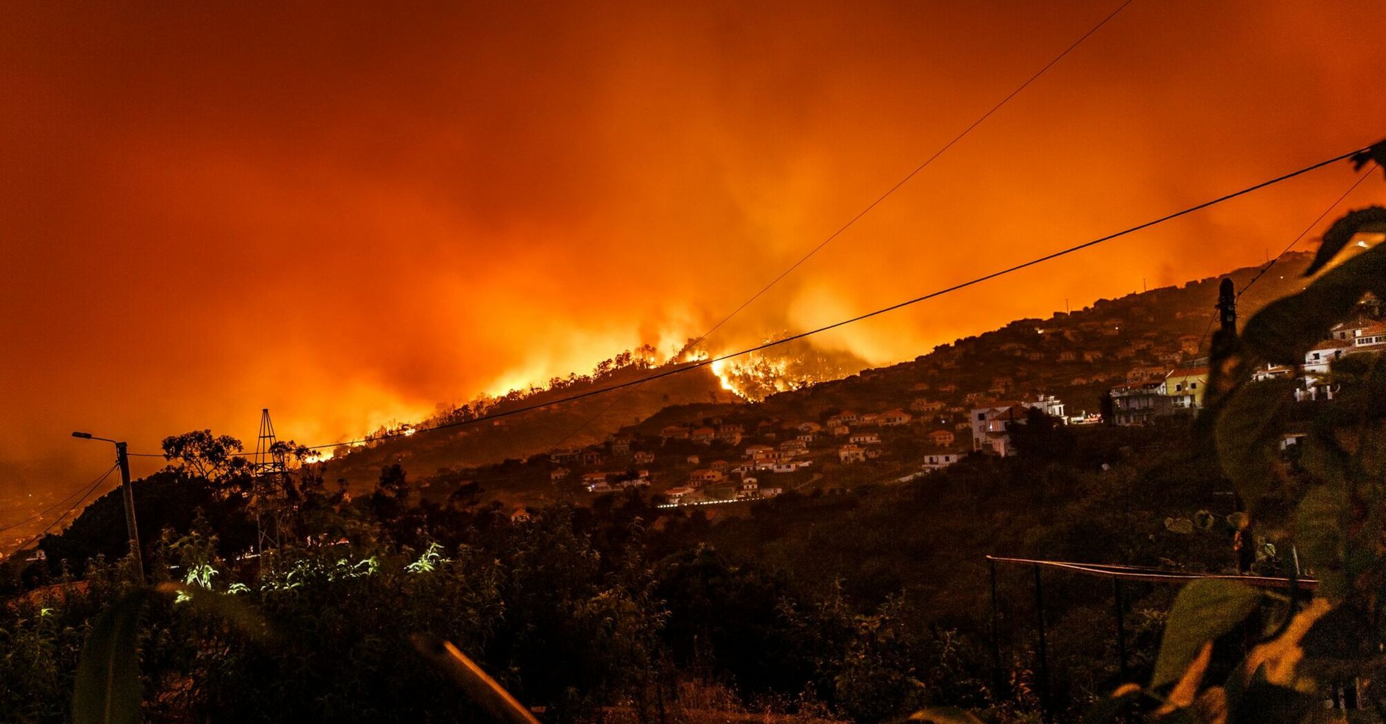 Hills engulfed in wildfire near residential homes