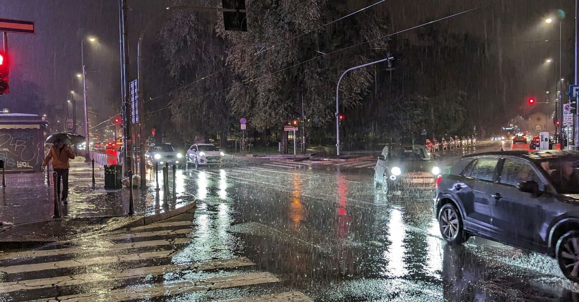 Rainy night at a city intersection with cars on wet streets