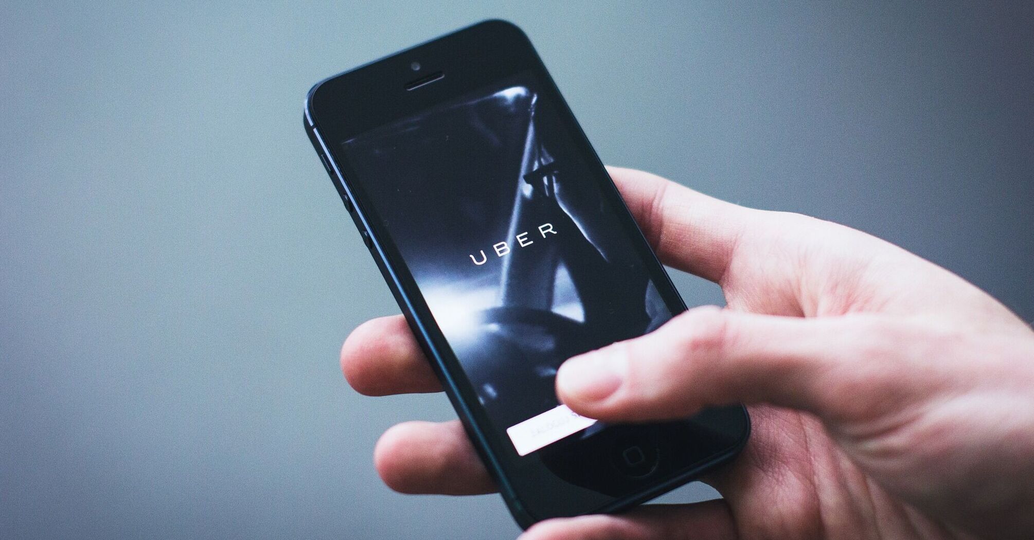 Person holding a smartphone with the Uber app open