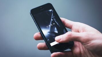 Person holding a smartphone with the Uber app open