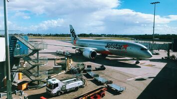 gray and orange jetstar airplane on parking