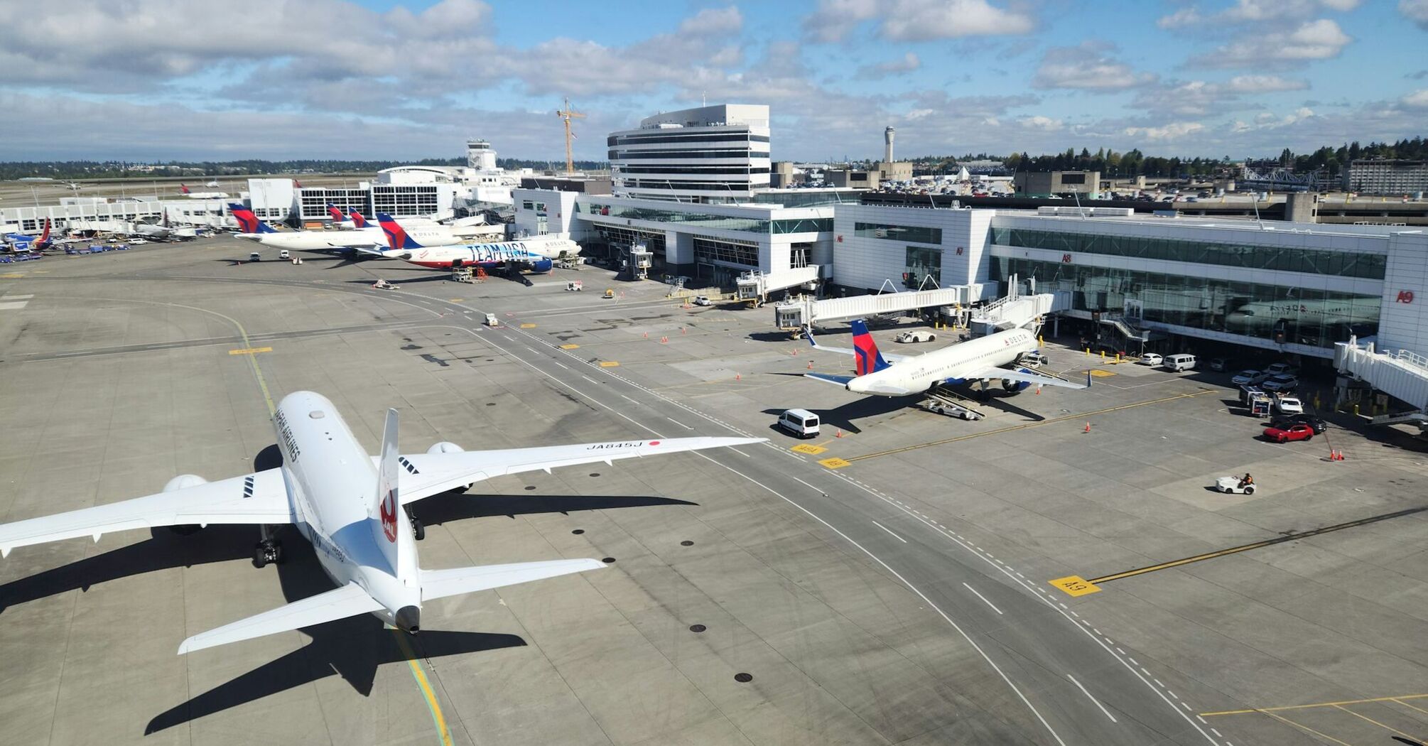 Wide view of an airport terminal with airplanes parked at the gates