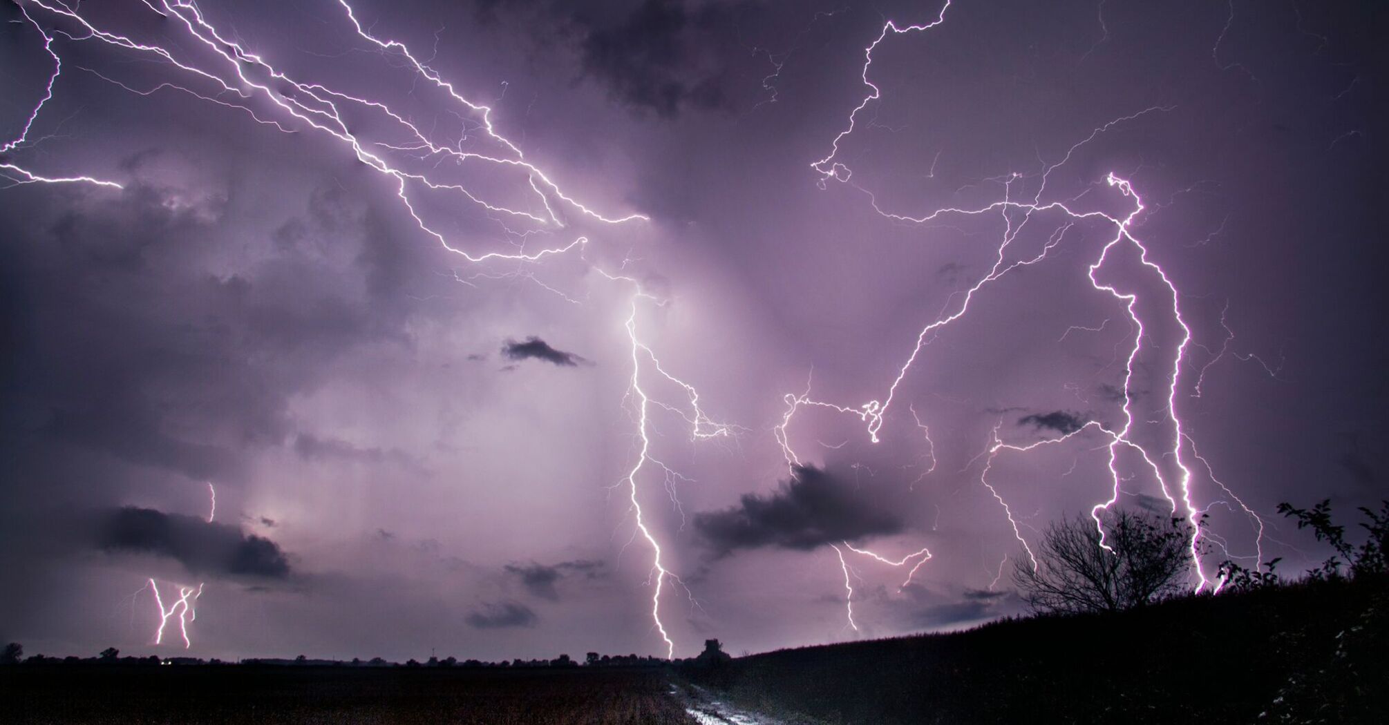 Dramatic lightning storm over a dark rural landscape