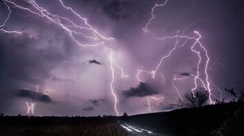 Dramatic lightning storm over a dark rural landscape