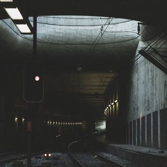 Interior of a dark railway tunnel with a red signal light