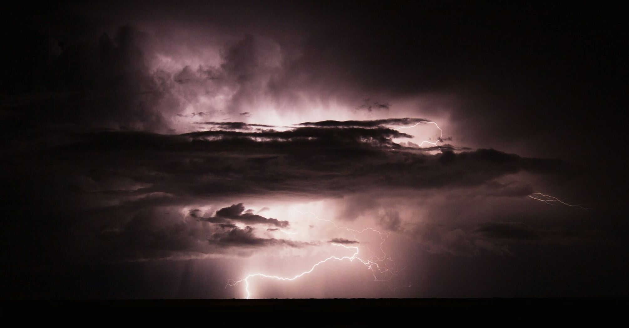 Dark storm clouds illuminated by lightning during a thunderstorm