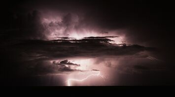 Dark storm clouds illuminated by lightning during a thunderstorm