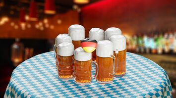 Beers served in traditional frothy mugs on a checkered Oktoberfest table