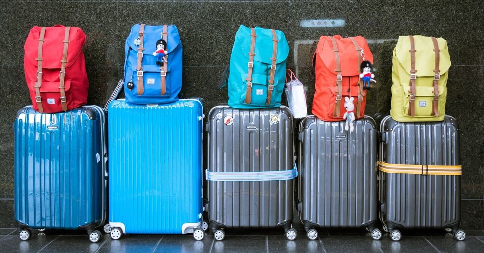 Backpacks and suitcases lined up on the floor