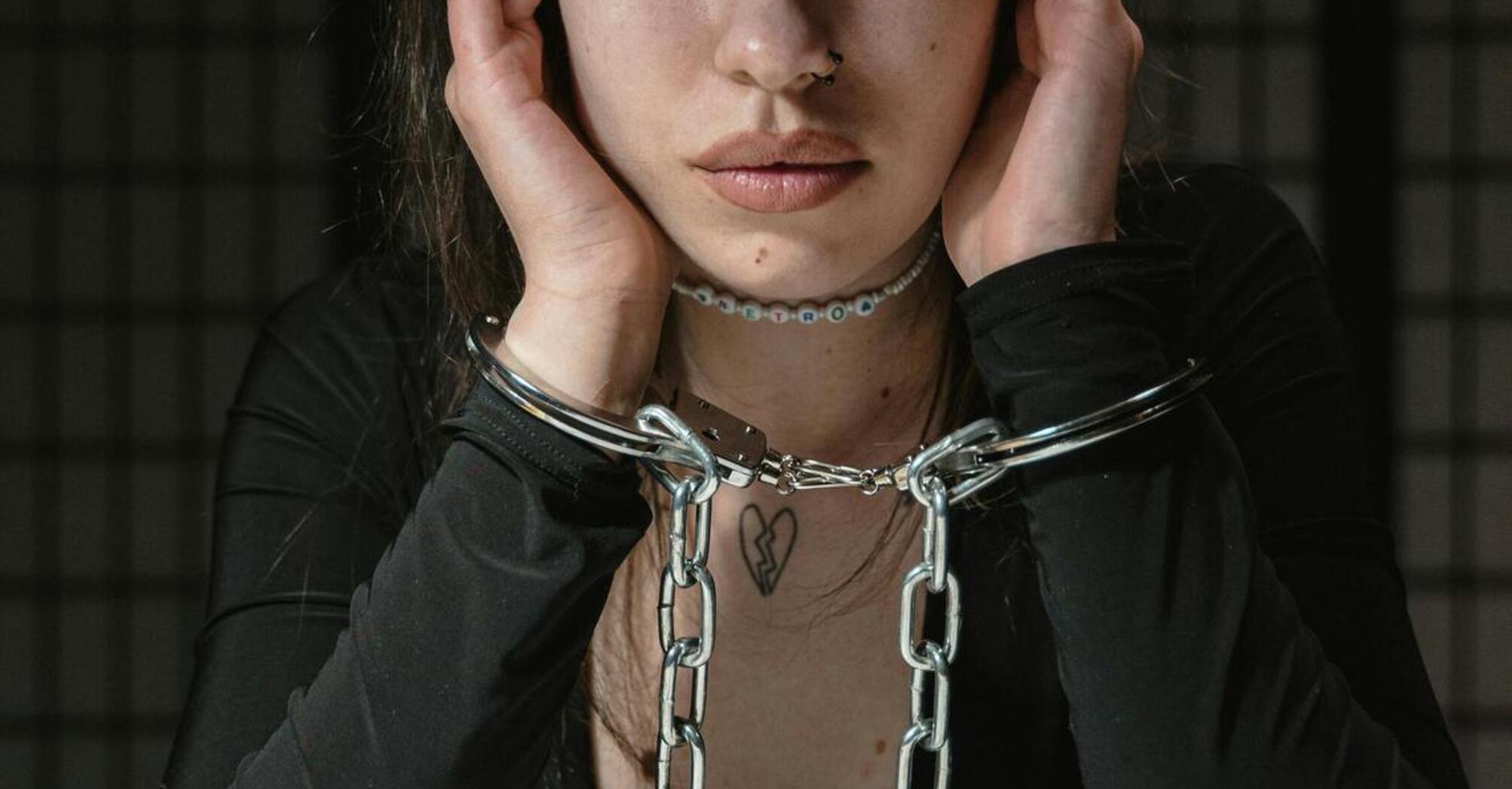 Woman in handcuffs sitting at a table with a distressed expression