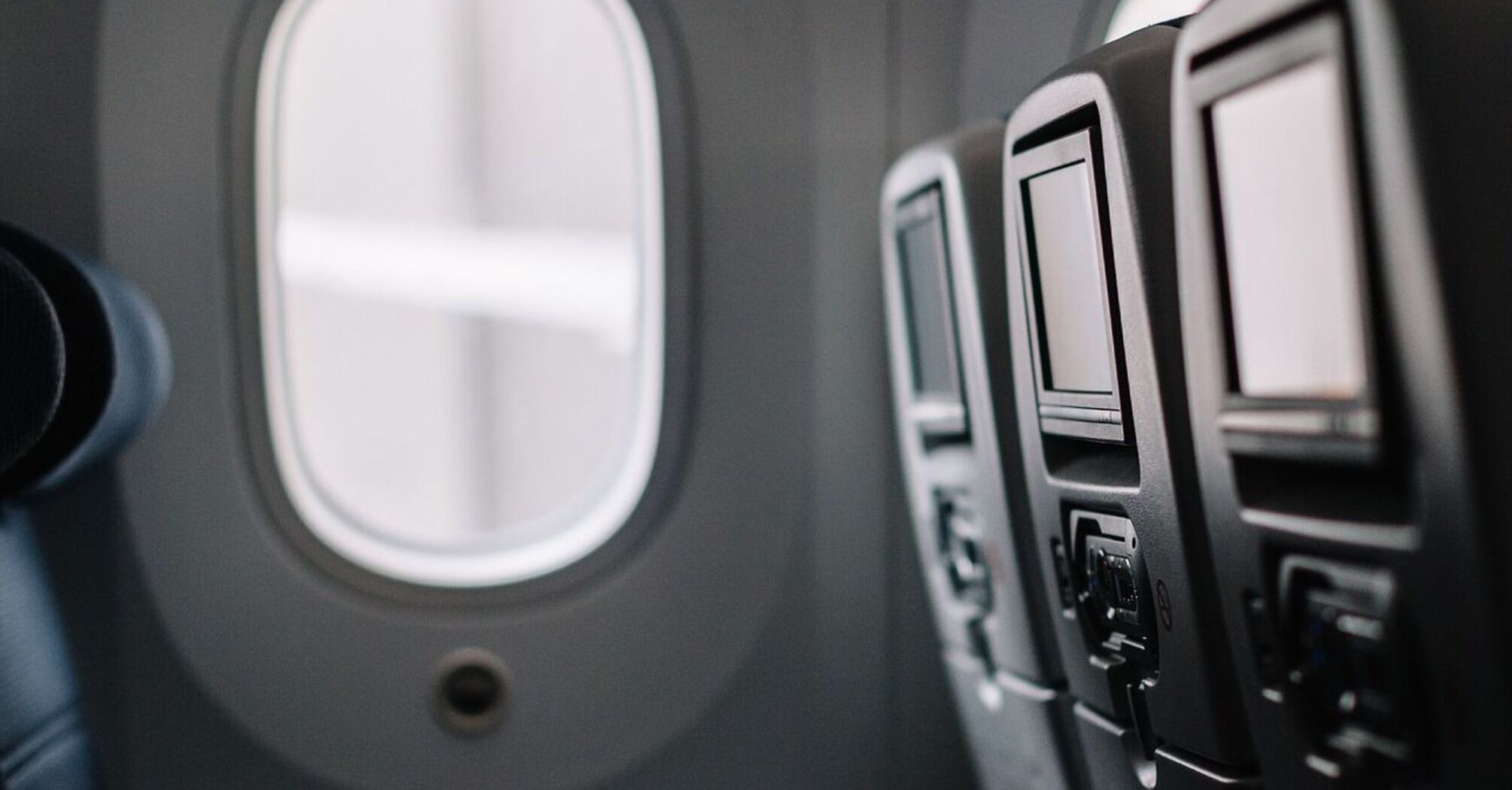 Empty airplane seats with seatback screens in an aircraft cabin