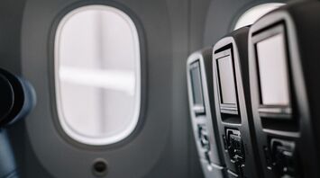 Empty airplane seats with seatback screens in an aircraft cabin