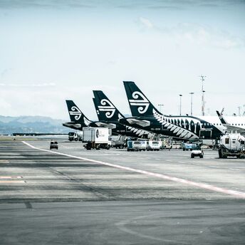 Air New Zealand planes lined up on an airport runway, preparing for international flights