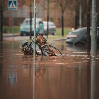Flooded street with a submerged bicycle near a pedestrian crossing