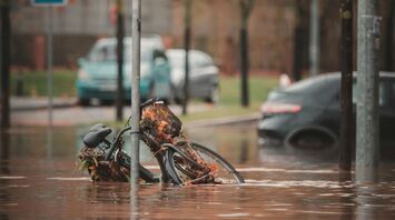 Flooded street with a submerged bicycle near a pedestrian crossing