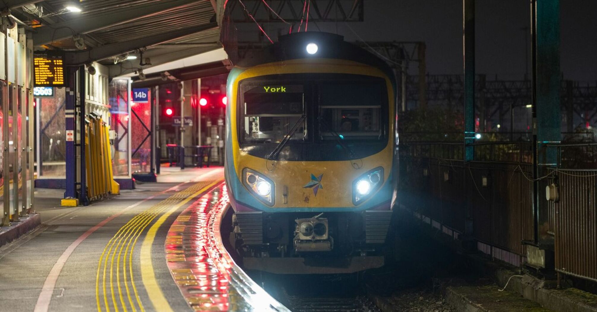 A TransPennine Express train bound for York, waiting at a station platform during the night