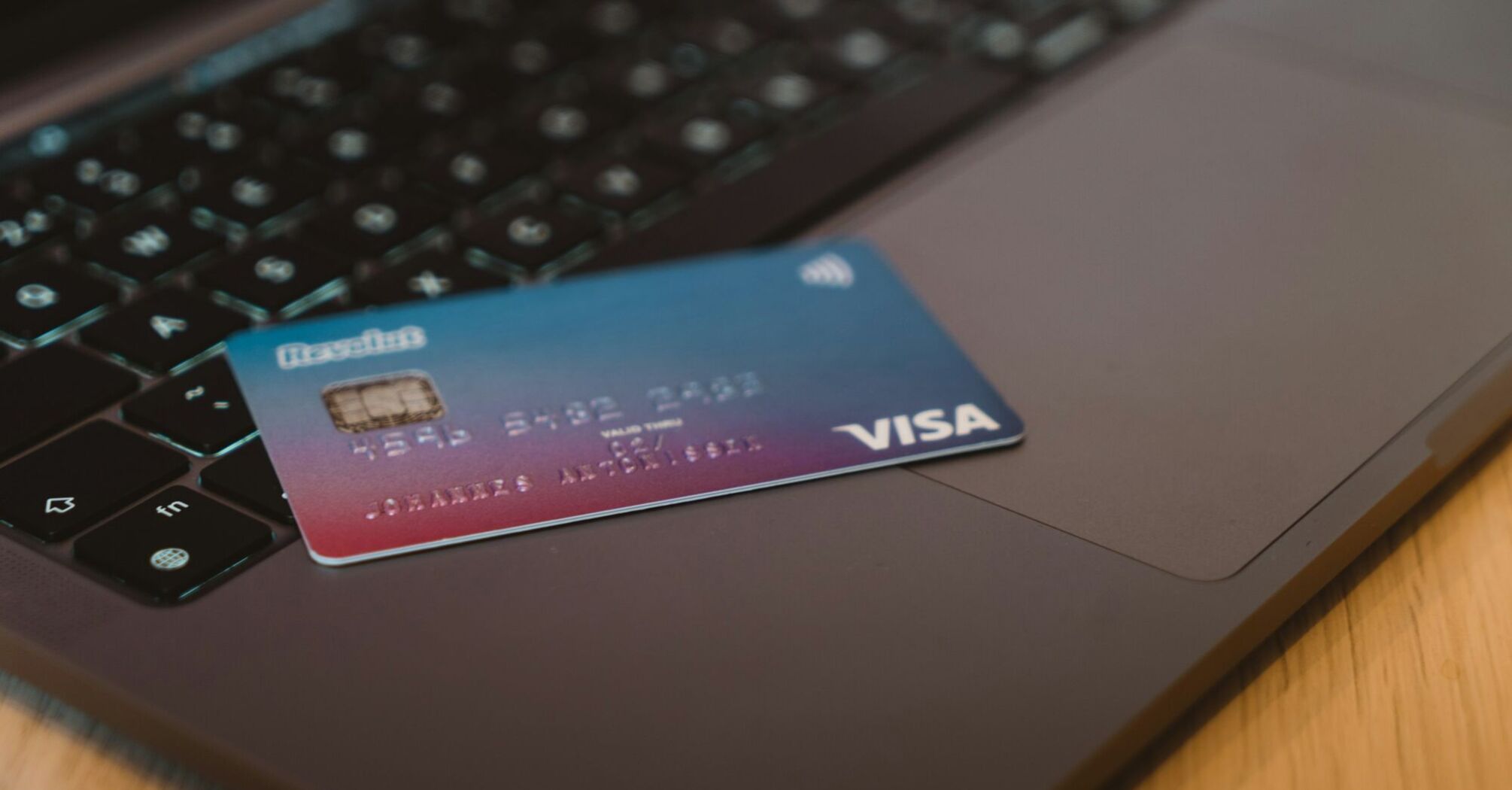 A Visa credit card placed on a laptop keyboard