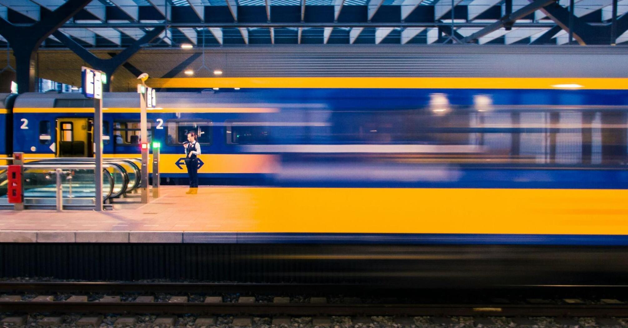 A high-speed train speeding past a modern platform at a European station