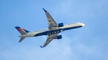 A Delta Airlines Airbus A350 aircraft flying through a clear blue sky