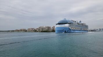 Icon of the Seas cruise ship sailing near a coastal city