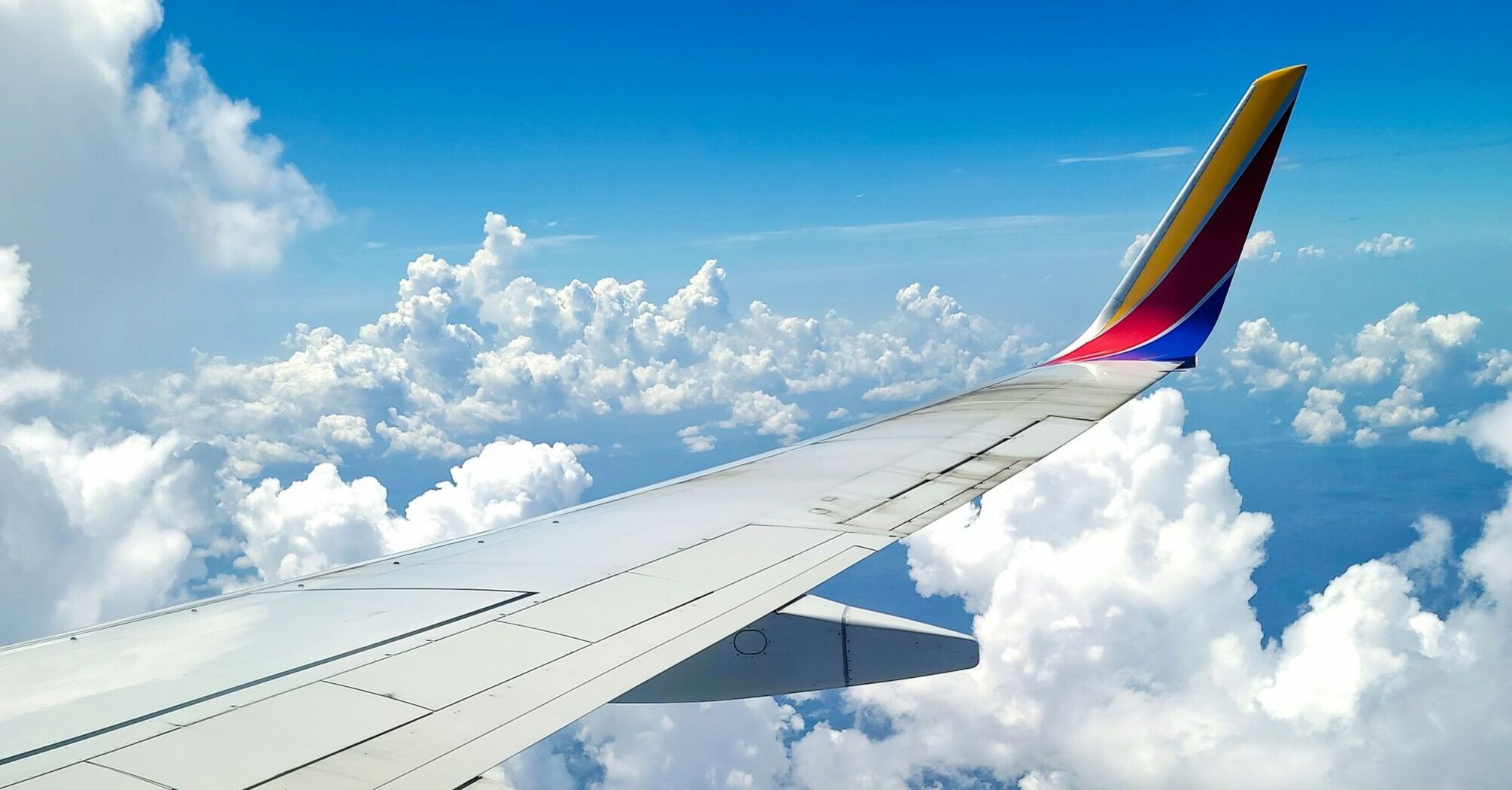 Wing of a Southwest Airlines plane in flight, above the clouds