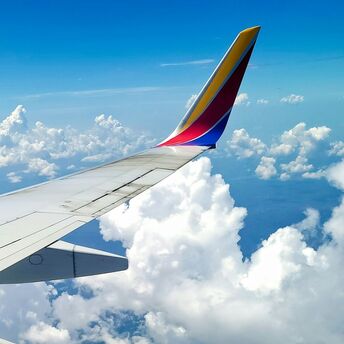 Wing of a Southwest Airlines plane in flight, above the clouds