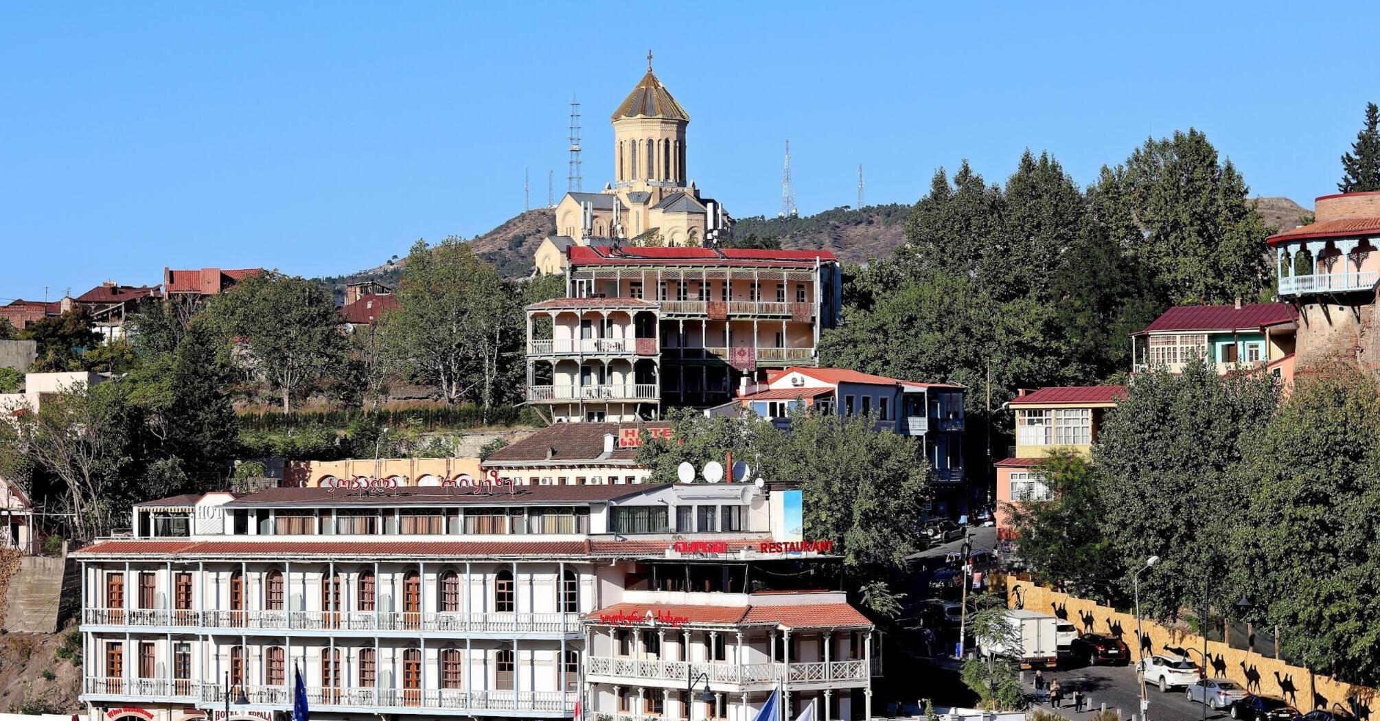 A scenic view of Tbilisi, showing traditional architecture and the Holy Trinity Cathedral overlooking the city