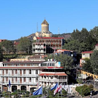 A scenic view of Tbilisi, showing traditional architecture and the Holy Trinity Cathedral overlooking the city