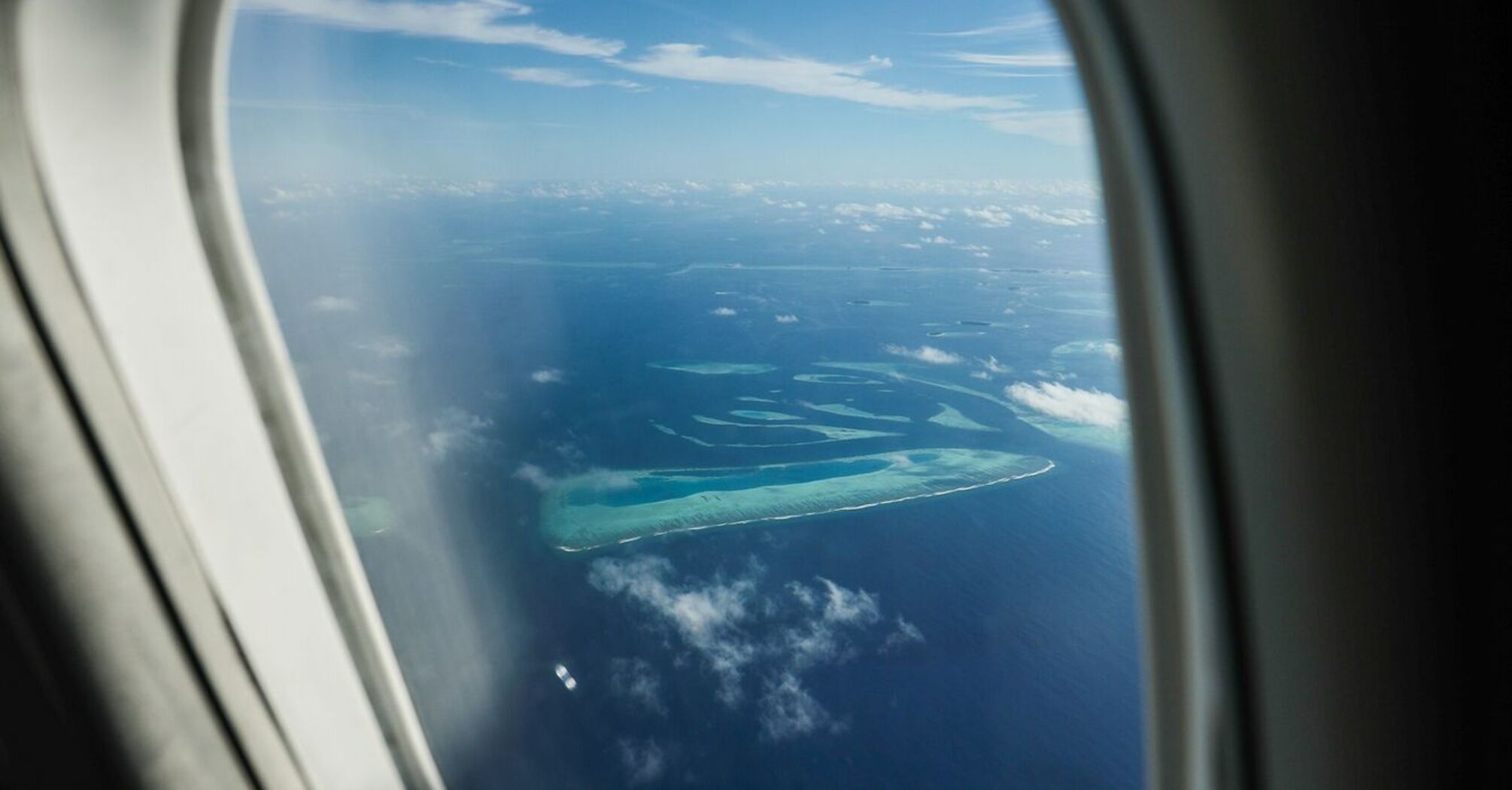 Aerial view of the Maldives' atolls seen through an airplane window