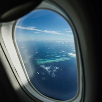 Aerial view of the Maldives' atolls seen through an airplane window