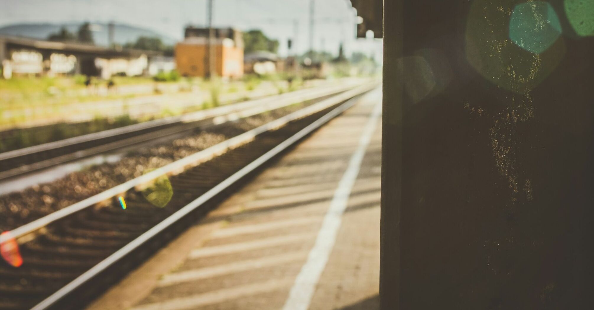 Empty train platform with railway tracks under soft sunlight