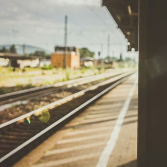 Empty train platform with railway tracks under soft sunlight