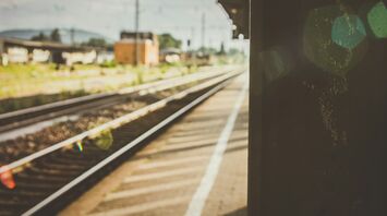 Empty train platform with railway tracks under soft sunlight