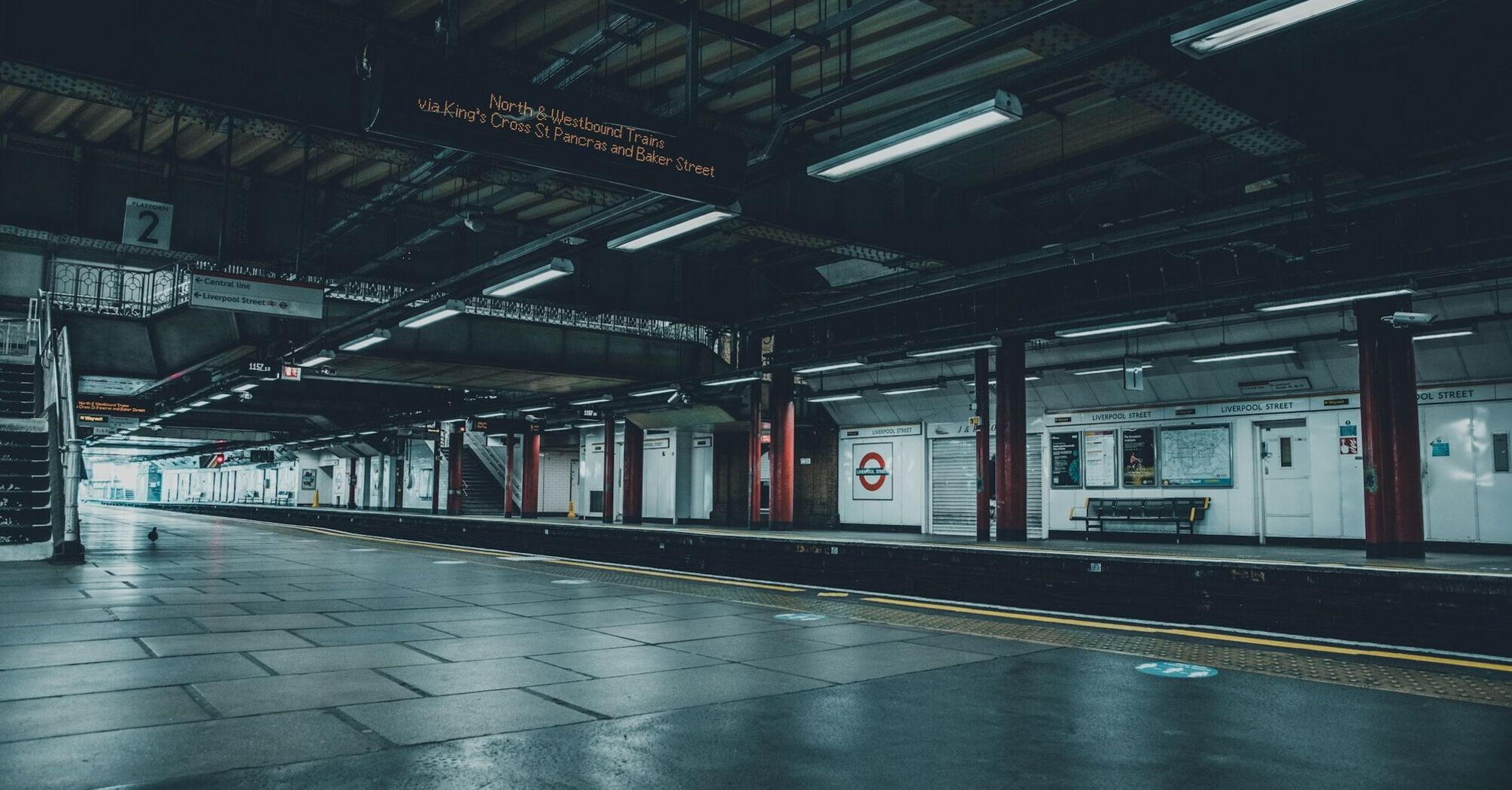 Empty London Liverpool Street train platform, dimly lit, with no passengers in sight