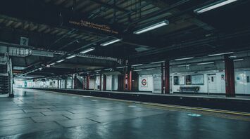 Empty London Liverpool Street train platform, dimly lit, with no passengers in sight